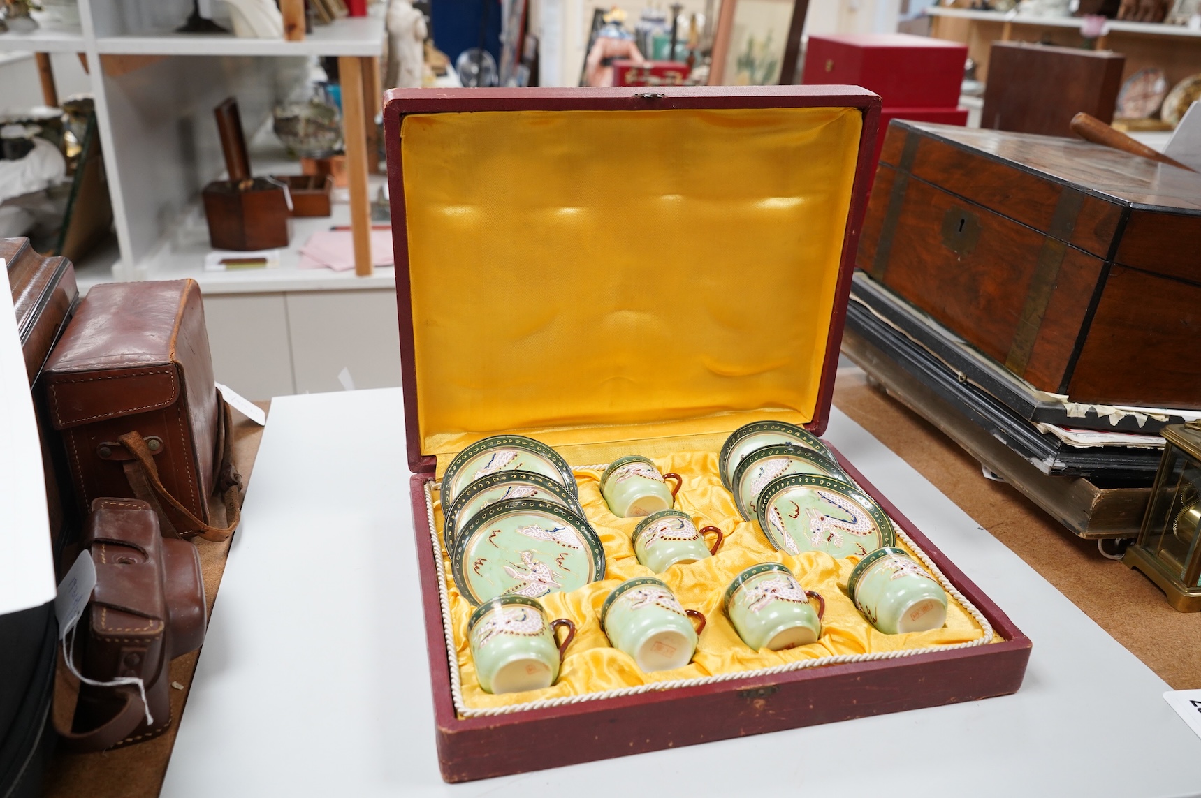 A cased Japanese coffee set, decorated with dragons on a green ground, case 34cm wide